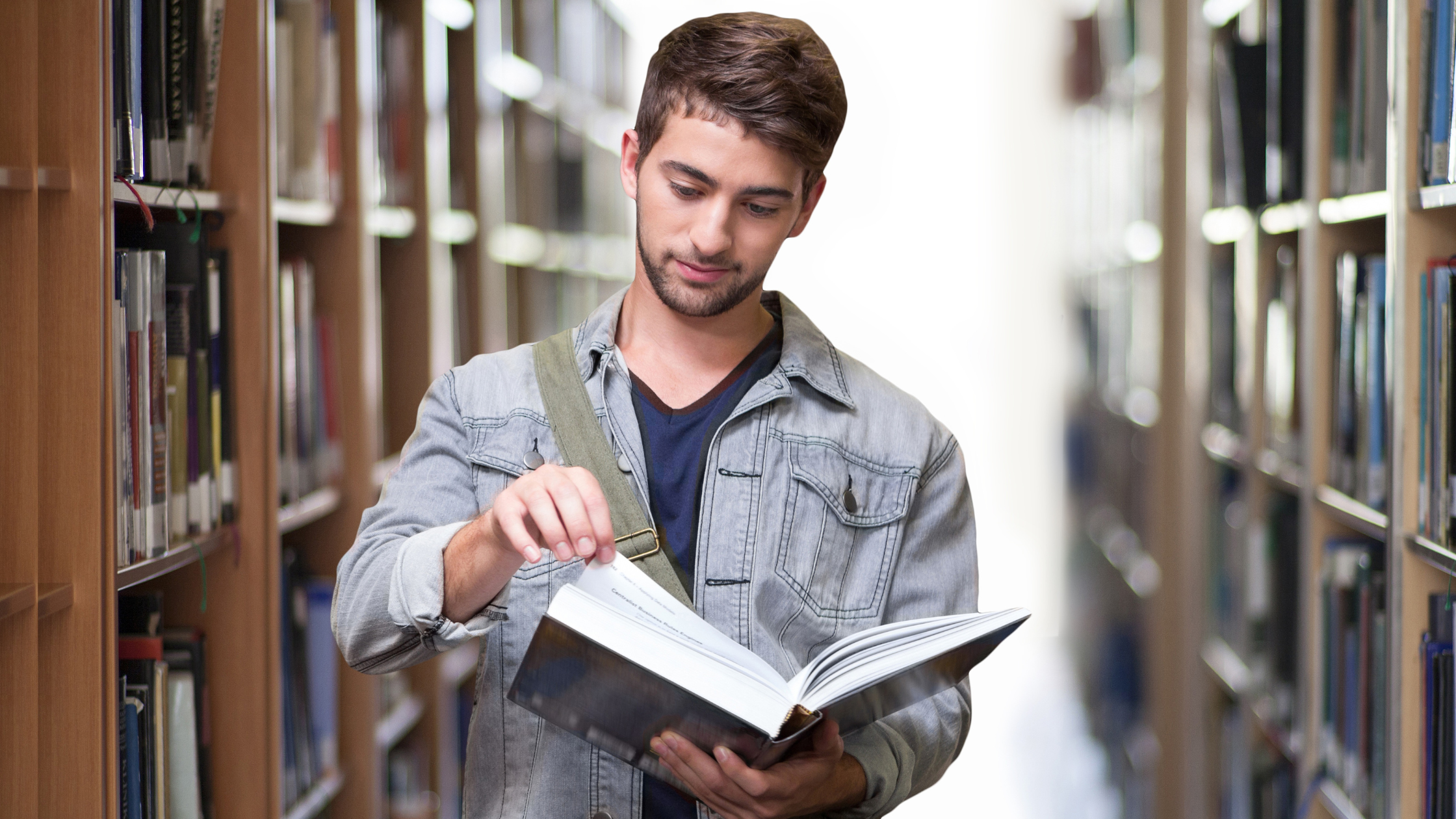Man in library reading a book and learning.